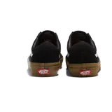 Championes Vans modelo Skate Old Skool, de color negro con la icónica banda lateral blanca. Presentan una suela de goma color caramelo y una etiqueta pequeña con el logo de tablero de ajedrez en el lateral.