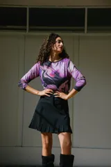 Remera de manga larga con cuello redondo y estampado abstracto en tonos magenta, negro y blanco.