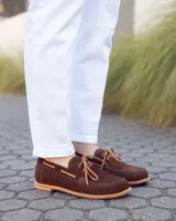 Zapato náutico de cuero gamuzado color marrón chocolate, con cordones y suela plana.