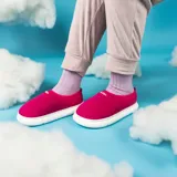 Pantuflas acolchadas color fucsia con diseño de costuras onduladas, suela de goma blanca y logo de la marca en dorado.