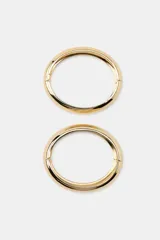 Pack de dos pulseras rígidas metálicas doradas de diseño minimalista y articulado, en diferentes grosores.
