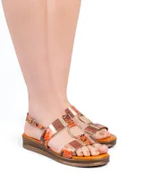 Sandalia Hush Puppies en colaboración con Massimo Cerutti, con plataforma baja y tiras con estampado de piel de serpiente en tonos naranja, combinadas con detalles metálicos, apliques con glitter y una argolla dorada central. Cuenta con tira ajustable con hebilla en el talón.