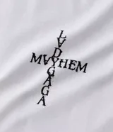 Remera blanca de algodón con modelado boxy, cuello redondo y manga corta. Presenta un estampado central en la parte delantera que forma una cruz con la palabra "MAYHEM" en el centro.