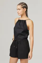 Top negro de lino con breteles finos regulables y escote fruncido.