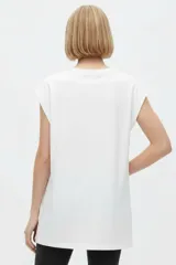 Remera negra de algodón, con cuello redondo, mangas cortas holgadas con vuelta y estampa floral grande en el pecho.