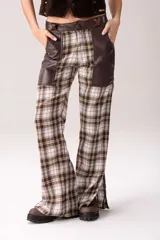 Pantalón de corte acampanado con diseño combinado. Presenta un estampado de cuadros tartán en tonos marrones, blancos y amarillos, con paneles laterales y bolsillos delanteros en cuero marrón oscuro.