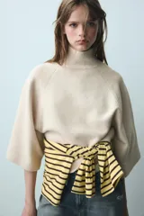 Jersey de punto verde militar, con cuello subido y mangas largas anchas de corte acampanado.