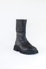 Bota de caña media color negro, de cuero, con suela track y cierre lateral.