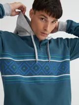 Canguro azul petróleo con capucha gris melange y media cartera de botones. Presenta una franja horizontal con motivos geométricos en blanco, azul y verde.