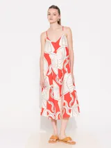 Vestido midi de algodón estampado color rojo con dibujos de abanicos en blanco y negro. Tiene escote en V, breteles finos regulables, espalda baja y bolsillos laterales.