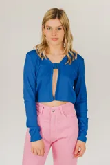 Top corto azul de tejido de punto acanalado, con mangas largas y cierre frontal con hebilla.