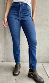 Jean de calce recto con lycra, color azul medio, con bolsillos delanteros y traseros.