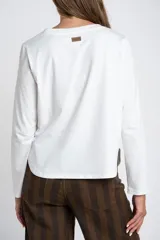 Remera de manga larga con cuello redondo, confeccionada en tejido de algodón con elastano, de calce ajustado al cuerpo.