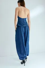 Pantalón globo en denim de algodón con elástico en la parte posterior de la pretina, piernas amplias con pinzas, bolsillos al bies y bajos abotonados.