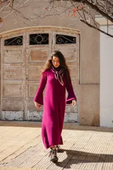 Vestido midi tejido en color fucsia, con cuello a la base, mangas largas semi oxford y detalle de calado en la parte inferior.