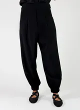 Pantalon negro de viscosa con pinzas en la cintura, bolsillos laterales y botamangas ajustadas.