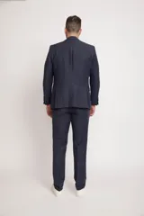 Ambo de corte comfort fit confeccionado en una mezcla de lino, viscosa y poliéster. El conjunto incluye un saco de dos botones con bolsillos laterales y un pantalón de corte recto, ofreciendo una textura suave y mayor resistencia a las arrugas que el lino tradicional.