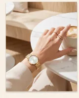 Reloj de pulsera analógico para mujer con caja y malla de eslabones en color dorado. Presenta una esfera minimalista de fondo claro con índices lineales y movimiento de cuarzo japonés.