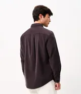 Camisa de hombre de corte regular confeccionada en terciopelo de algodón, con cuello clásico, cierre frontal de botones y dos bolsillos con solapa en el pecho.