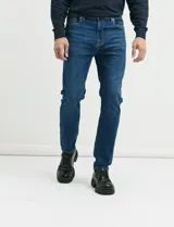 Pantalón de jean de corte recto slim, con diseño clásico de cinco bolsillos y cierre frontal con botón y cremallera.