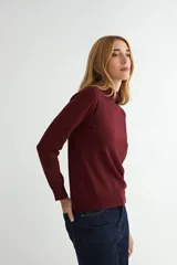 Polera de punto color beige, con cuello alto y mangas largas, de diseño básico y ajuste clásico.