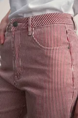 Pantalón jean de corte recto, color rojo con finas rayas verticales blancas.