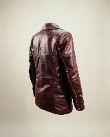 Blazer de cuero bovino color bordó, con silueta entallada, solapas clásicas y cierre frontal con un botón. Presenta mangas largas con detalles fruncidos que aportan textura.