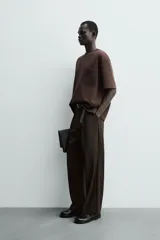 Remera de corte relajado confeccionada en tejido compacto de mezcla de algodón con elasticidad. Presenta cuello redondo, manga corta y un bolsillo frontal de plastrón.