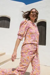 Pantalón de tiro medio con corte semi-oxford y tajos en el ruedo. Presenta un estampado floral en tonos rosados y naranjas.