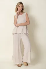 Pantalón palazzo blanco de lino italiano, con cintura elastizada y lazos de seda en los tobillos.