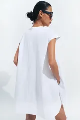 Vestido corto Zara de la colección ZW Collection, color beige, confeccionado en mezcla de algodón. Presenta cuello redondo, manga corta, bolsillos laterales ocultos en costura, bajo evasé y cierre en la espalda con cremallera.