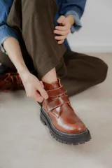 Botas cortas de cuero color hueso, con puntera redondeada, ajuste con doble tira con velcro color verde oliva y suela track color negro.