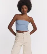 Blusa cropped sin breteles, confeccionada en tejido rib con textura acanalada. Presenta un diseño ajustado y liso.