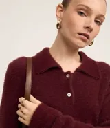 Saco de punto afelpado color bordó, de manga larga, con cuello polo y cierre frontal de dos botones.