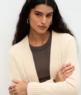 Cardigan alargado Marfinno de punto texturizado color marfil, con diseño abierto, mangas largas y puños canelados.