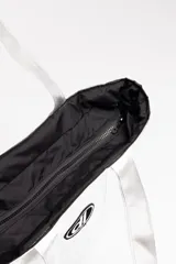 Bolso shopper plateado acolchado, con diseño puffer y costuras a cuadros. Cuenta con tiras para el hombro y un parche ovalado negro y blanco con las iniciales dl en el centro.