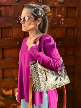 Cartera tipo tote bag con estampado animal print, doble asa de mano color cuero y correa larga desmontable y regulable.