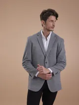 Blazer formal color negro, confeccionado en tela texturada, con solapas clásicas, cierre de dos botones frontales y bolsillos con solapa.