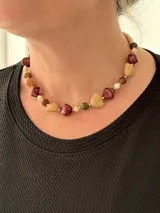 Collar corto compuesto por cuentas de cristales checos facetados, piedras naturales en tonos tierra, bordó y verde, y abalorios metálicos dorados.