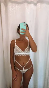 Set de lencería de cuatro piezas compuesto por bralette de encaje y microtul, tanga regulable, portaligas y ligas. Diseño con transparencias y detalles de encaje.
