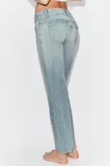 Jeans de tiro bajo con corte flare, confeccionados en denim azul con lavado localizado. Presentan bolsillos de plastrón en el frente, trabillas para cinturón y cierre frontal con cremallera y botones metálicos.