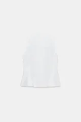 Camisa de cuello subido y manga sisa, confeccionada en tejido a rayas azules y blancas. Presenta bajo acabado en peplum y cierre frontal con nudos de pasamanería.