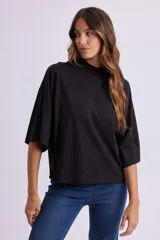 Remera negra de corte holgado, con cuello alto y mangas 3/4.