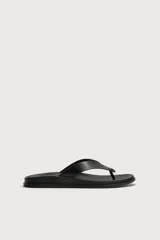 Sandalias de dedo color negro con suela plana y tiras anchas en el empeine con diseño de chancleta.