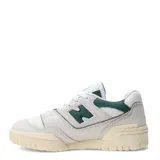 Championes New Balance modelo 550, color blanco hueso con detalles en verde oscuro. Presentan un diseño de corte bajo inspirado en el básquet, con paneles de cuero y malla, y el logo 'N' en verde oscuro. La suela es de goma color crema.