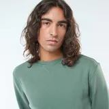 Buzo de felpa perchada color verde con cuello redondo y mangas largas.