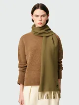 Bufanda de lana en color verde oliva, con diseño liso, flecos en los extremos y pequeño logo de corazón bordado en la parte inferior.