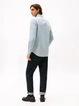 Camisa de manga larga Tommy Hilfiger con estampado Tattersal en tonos celeste y blanco. Confeccionada en tejido Oxford de algodón regenerativo, con cuello abotonado, cierre con botones y logo bordado en el pecho.