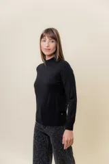 Buzo de tejido fino color amarillo claro, con cuello semi alto, manga larga y calce regular.