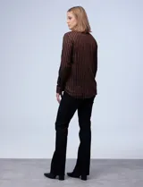 Camisa de manga larga con estampado a rayas verticales marrones y negras. Tiene cuello con solapa, abertura central con botones y bolsillo en el pecho.